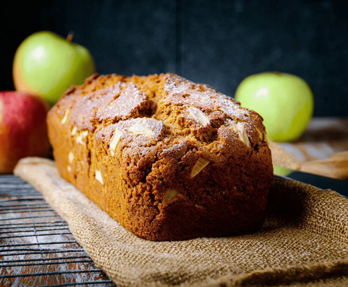 Homemade Pumpkin Apple Bread topped with walnuts, sliced open to reveal moist, spiced pumpkin and apple filling, perfect for fall baking.