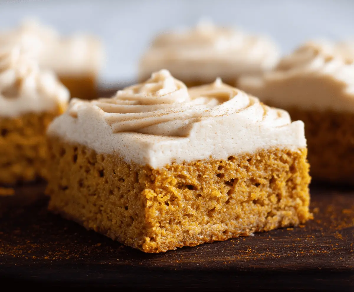 Delicious pumpkin bars topped with creamy brown sugar frosting on a festive plate, perfect for fall desserts