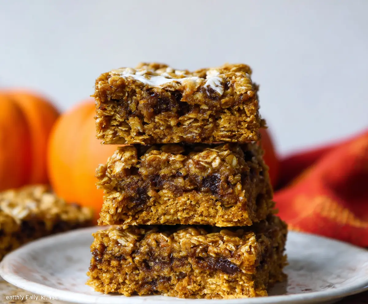 Delicious homemade pumpkin oatmeal bars with a golden crust and spiced pumpkin filling, perfect for fall treats.