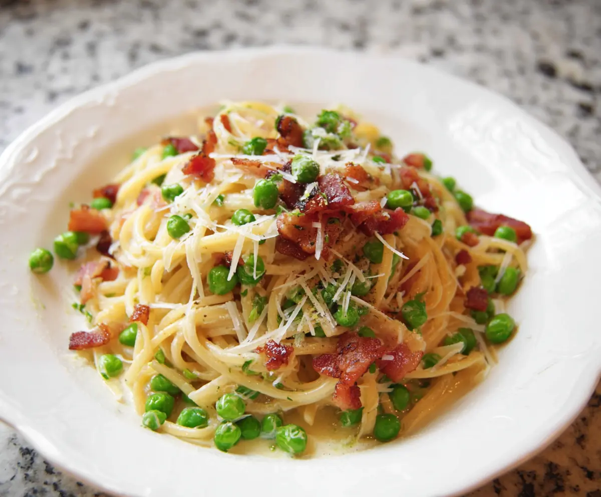 Delicious bacon and pea pasta dish showcasing crispy bacon pieces and fresh green peas in a creamy sauce.