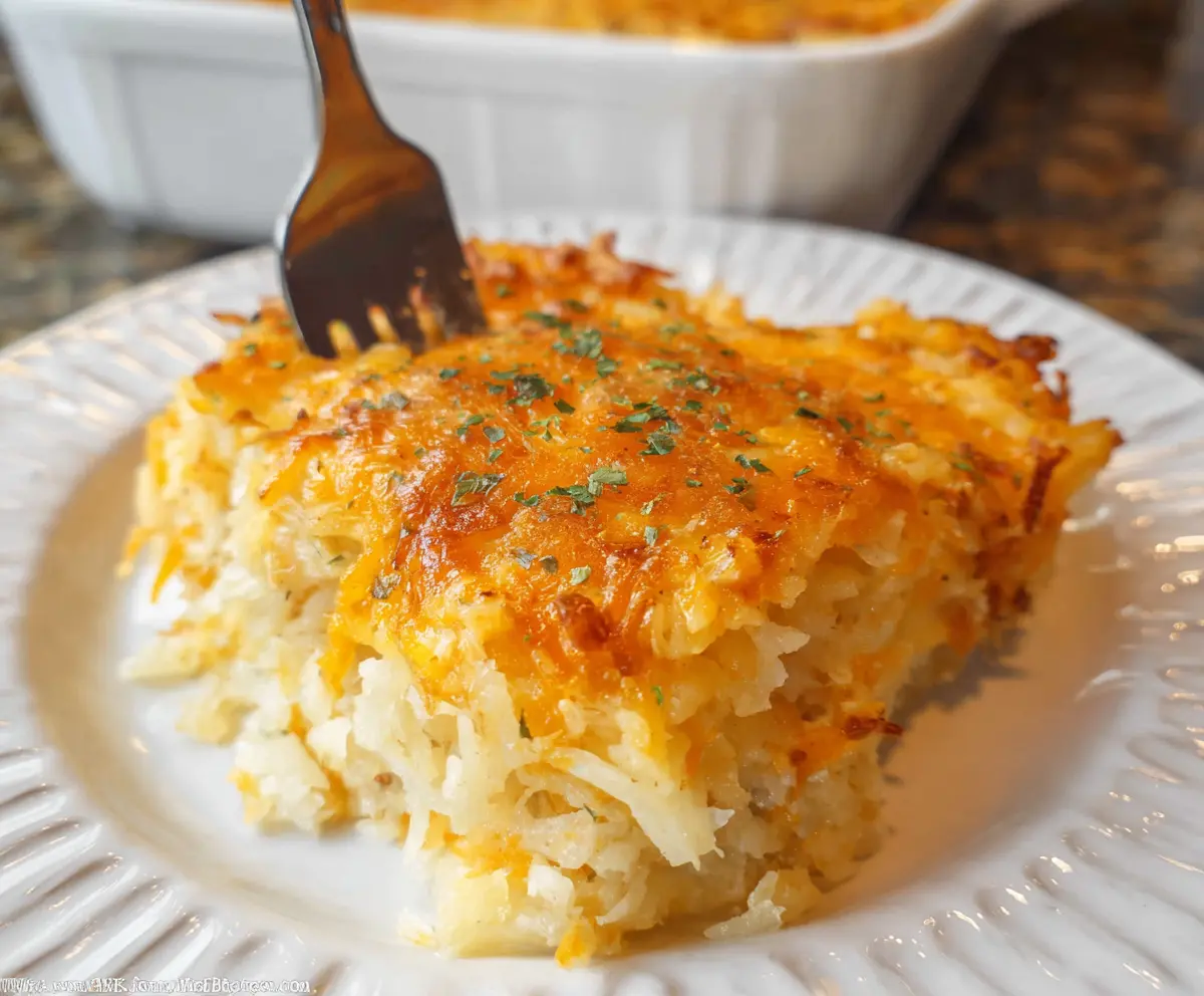 Delicious Cracker Barrel Hashbrown Casserole served in a baking dish, showcasing crispy hashbrowns topped with melted cheese.