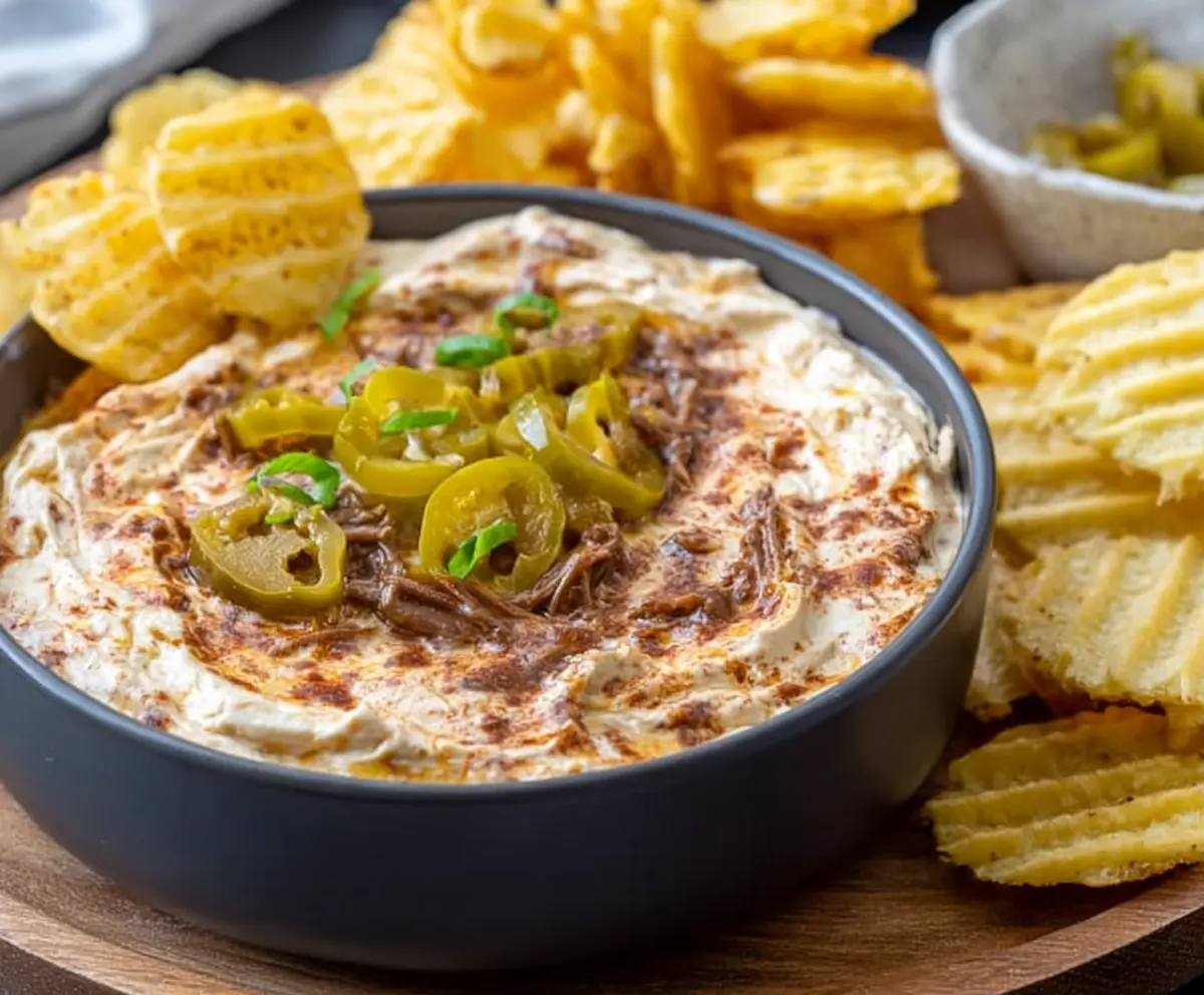 Delicious Mississippi Pot Roast Dip served in a bowl, featuring tender shredded beef and melted cheese.