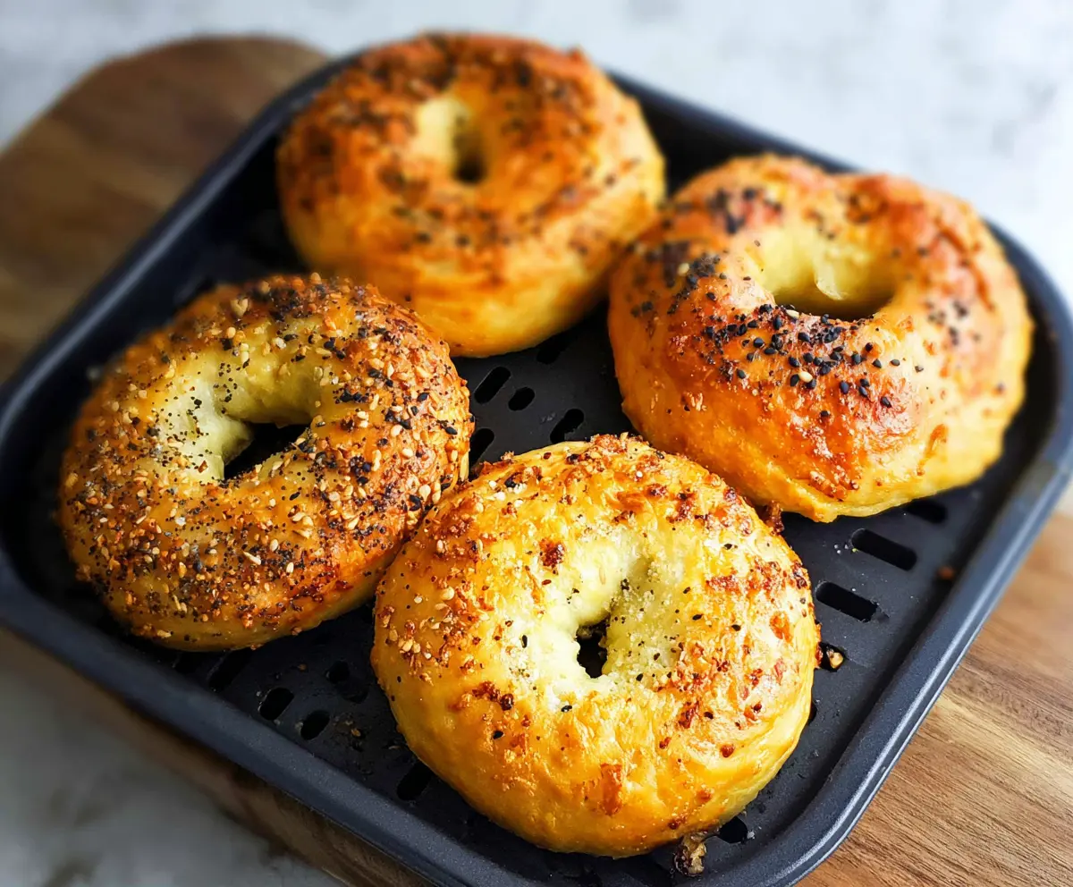 Delicious 3 Ingredient Air Fryer Bagels on a baking tray, showcasing a golden-brown crust.