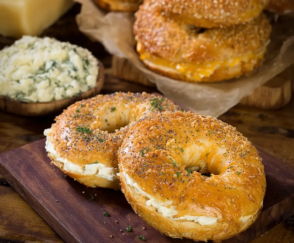 Close-up of freshly baked creamy cheddar bagels on a rustic wooden surface